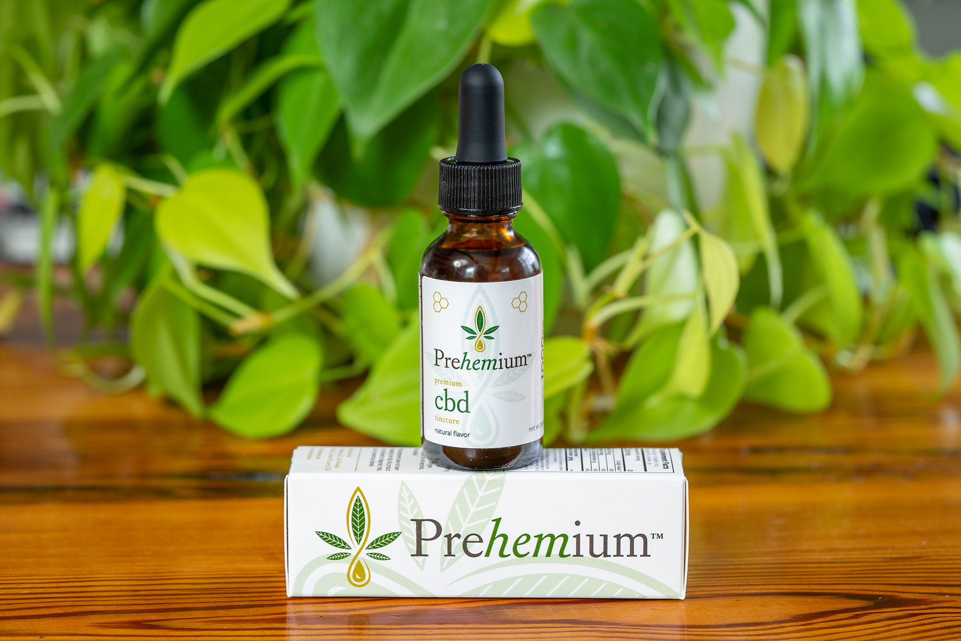 Premium Full-Spectrum CBD Tincture - Natural. Bottle is placed on top of the box which is sideways showcasing the lengthwise prehemium logo.